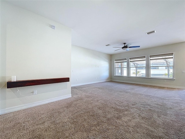 empty room featuring baseboards, carpet flooring, a ceiling fan, and visible vents