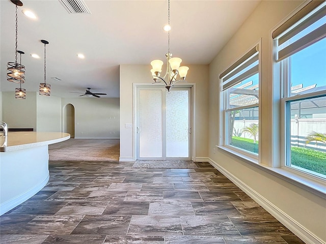 unfurnished dining area featuring visible vents, arched walkways, baseboards, and recessed lighting