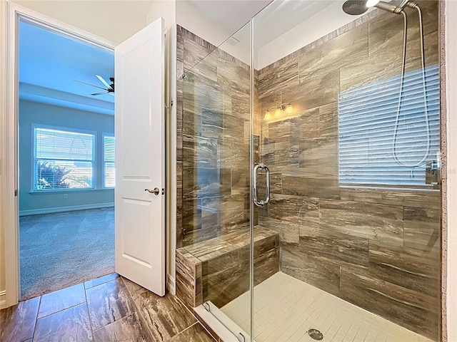 bathroom with a ceiling fan and a shower stall