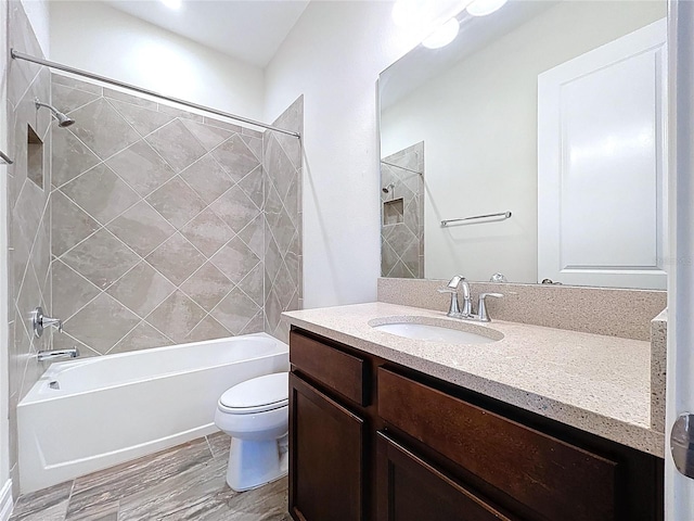 bathroom featuring vanity, bathtub / shower combination, toilet, and wood finished floors