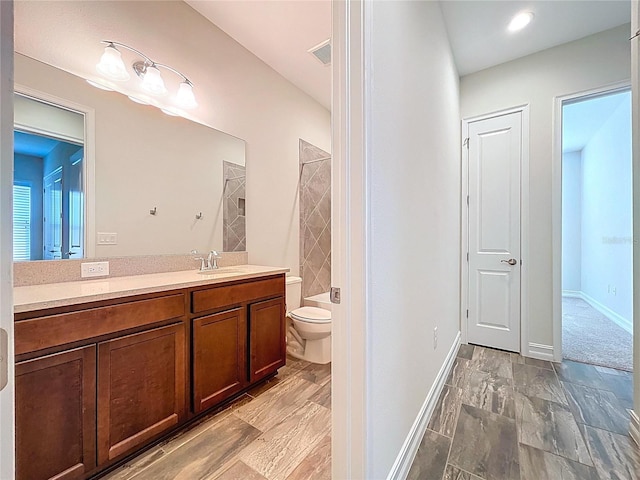 full bath with vanity, baseboards, a shower, and toilet