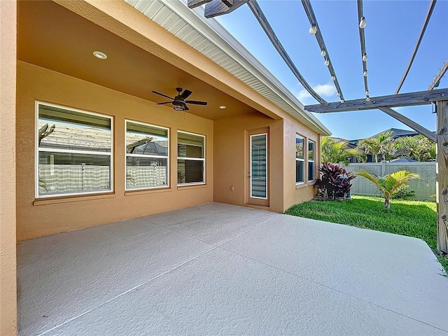 view of patio with fence and a ceiling fan