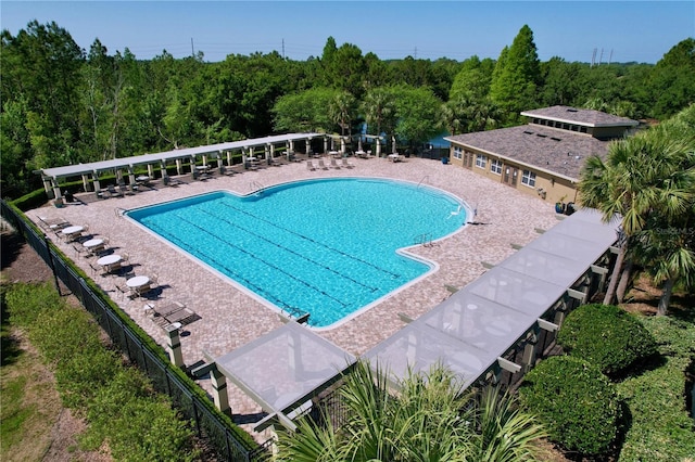 community pool with a patio and fence