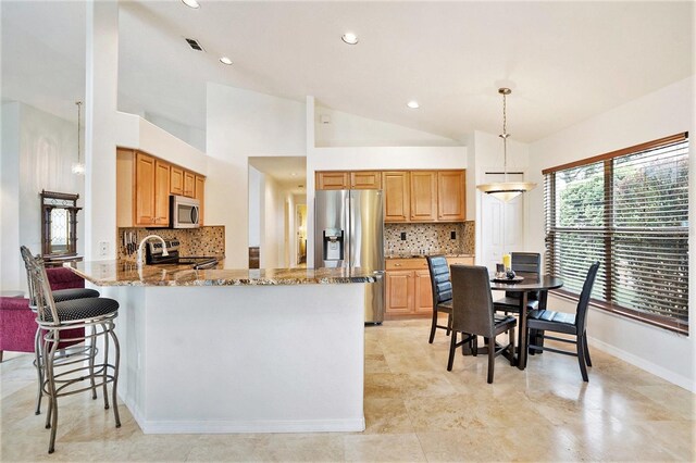 3023 Bent Creek Dr, Valrico, FL 33596 - kitchen with stainless steel appliances, light stone counters, backsplash, a peninsula, and lofted ceiling