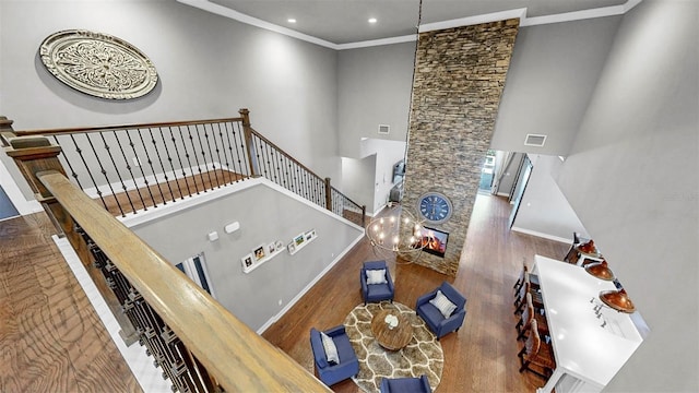 stairs featuring crown molding, a high ceiling, recessed lighting, wood finished floors, and visible vents