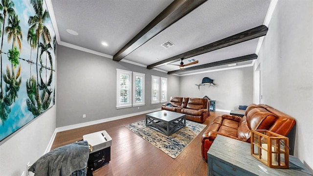 living room featuring visible vents, wood finished floors, beamed ceiling, baseboards, and a ceiling fan