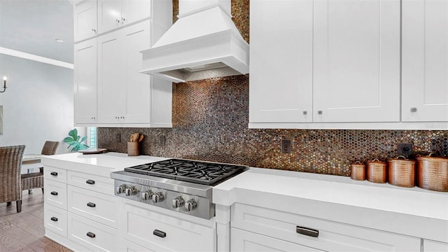 kitchen featuring light countertops, white cabinets, stainless steel gas cooktop, and custom exhaust hood