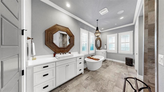 full bath featuring crown molding, a sink, a freestanding bath, and two vanities