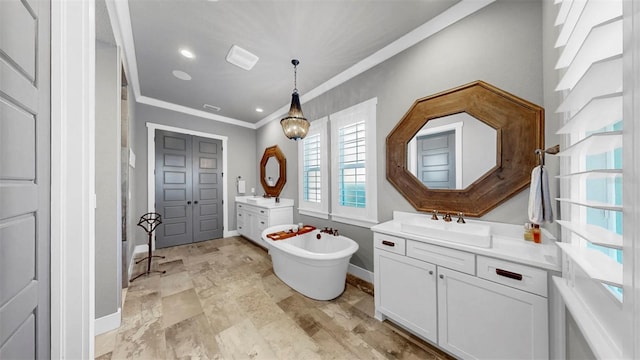 bathroom featuring a sink, baseboards, two vanities, ornamental molding, and a soaking tub