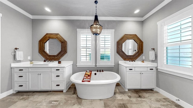 bathroom featuring ornamental molding, a freestanding tub, baseboards, two vanities, and a sink