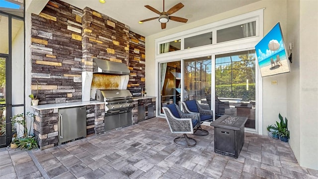 view of patio featuring ceiling fan, a grill, and an outdoor kitchen