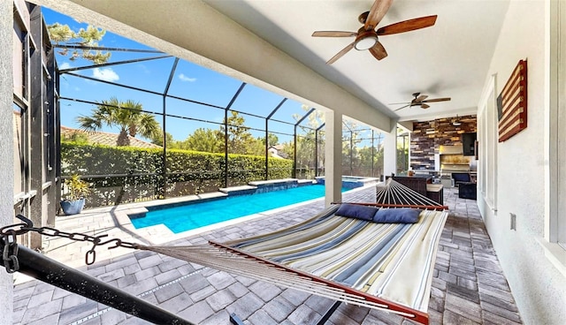 view of pool featuring a pool with connected hot tub, a patio, ceiling fan, outdoor lounge area, and a lanai