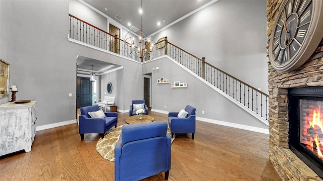 living area featuring a high ceiling, a fireplace, stairs, baseboards, and wood finished floors