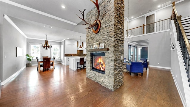 living room with ornamental molding, dark wood-style flooring, stairs, and visible vents