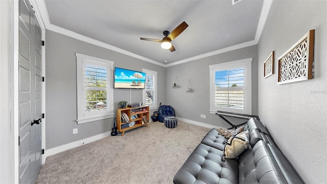 living area featuring carpet floors, ceiling fan, crown molding, and baseboards