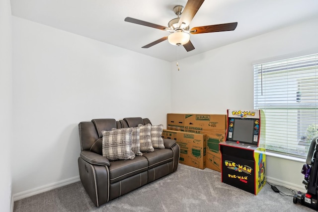 sitting room featuring ceiling fan, carpet flooring, and baseboards