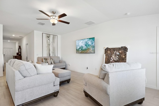 living area featuring visible vents and ceiling fan