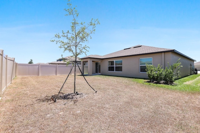back of property featuring stucco siding and a fenced backyard