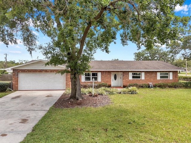 424 Forest Glen Ave, Lakeland, FL 33813 - ranch-style home with a garage, concrete driveway, a front lawn, and brick siding