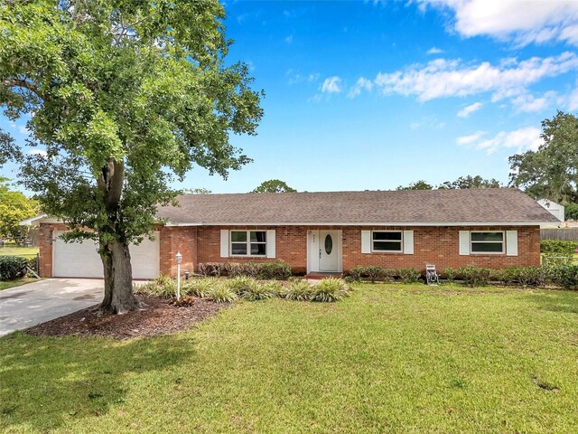 424 Forest Glen Ave, Lakeland, FL 33813 - single story home with concrete driveway, a front lawn, a garage, and brick siding