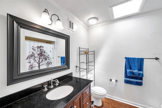 424 Forest Glen Ave, Lakeland, FL 33813 - bathroom with crown molding, toilet, vanity, wood finished floors, and baseboards