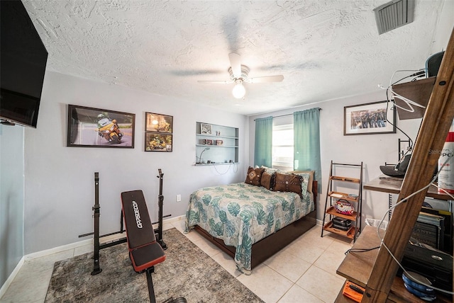 bedroom with ceiling fan, a textured ceiling, visible vents, light tile patterned floors, and baseboards