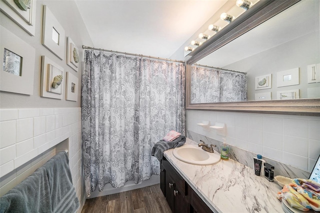 bathroom with vanity, curtained shower, wood finished floors, a fireplace, and tile walls