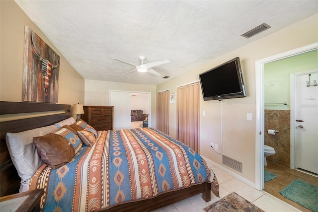 tiled bedroom featuring a textured ceiling, ensuite bathroom, ceiling fan, and visible vents