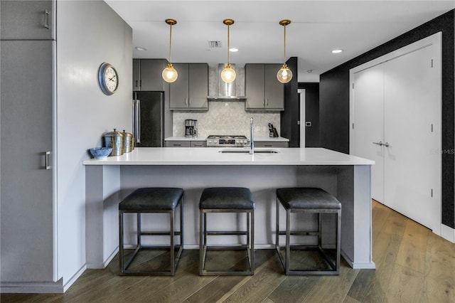 199 Dali Blvd Unit 902, Saint Petersburg, FL 33701 - kitchen featuring refrigerator, wall chimney exhaust hood, a sink, dark wood finished floors, and a kitchen bar