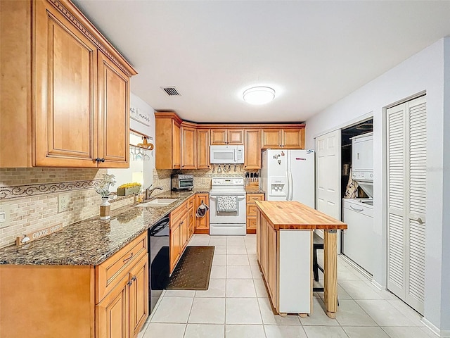 3078 Pointer Dr, Palm Harbor, FL 34683 - kitchen with backsplash, stacked washer / dryer, visible vents, wood counters, and white appliances