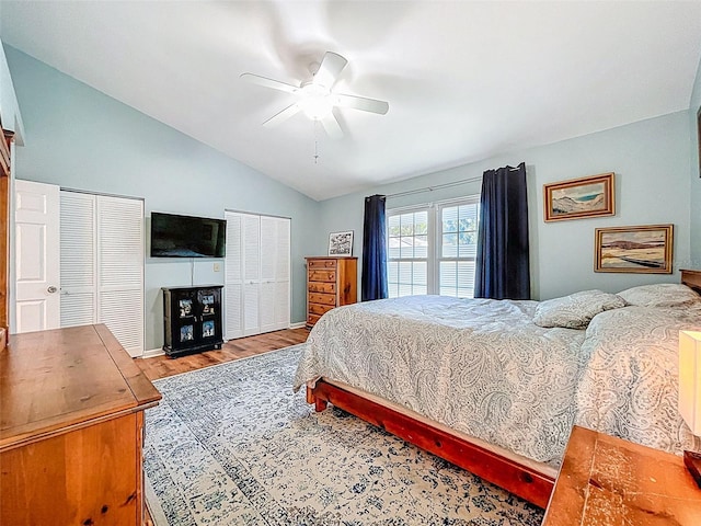 3078 Pointer Dr, Palm Harbor, FL 34683 - bedroom featuring ceiling fan, wood finished floors, vaulted ceiling, and two closets