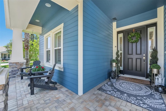 doorway to property featuring visible vents and covered porch