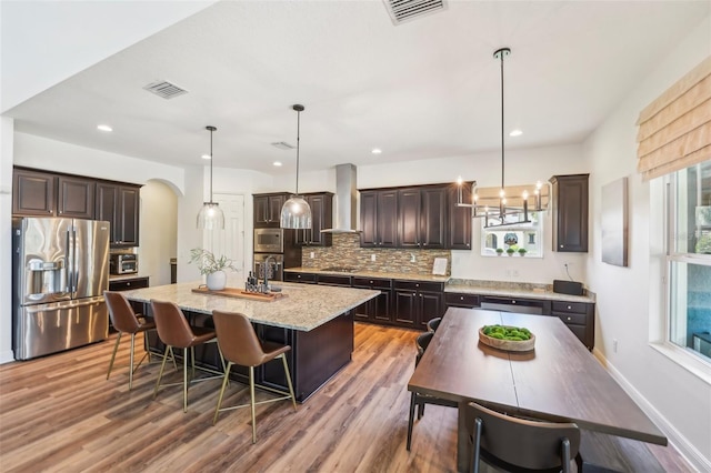 kitchen with visible vents, wall chimney exhaust hood, plenty of natural light, and stainless steel appliances