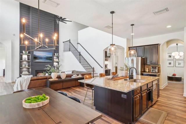 kitchen with visible vents, arched walkways, a sink, and ceiling fan