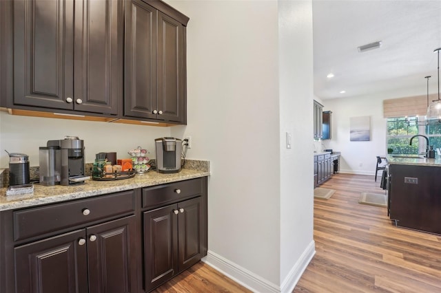 bar with visible vents, a sink, baseboards, light wood-style floors, and recessed lighting