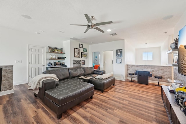 living area featuring baseboards, a ceiling fan, wood finished floors, and visible vents