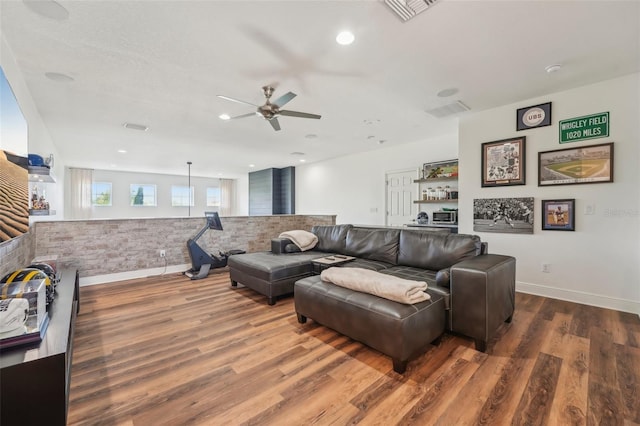 living area featuring baseboards, a ceiling fan, wood finished floors, and visible vents