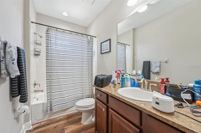 bathroom with vanity, toilet, wood finished floors, and shower / bath combination with curtain