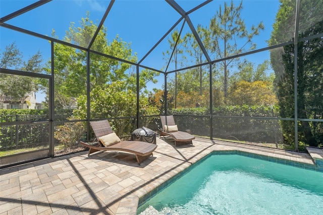 pool featuring glass enclosure and a patio
