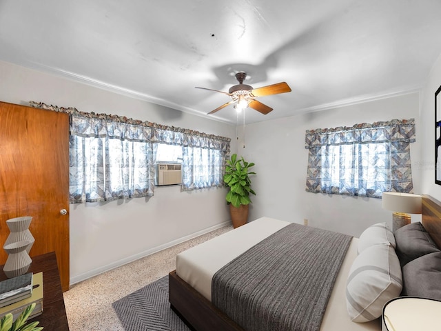 bedroom with a ceiling fan, baseboards, speckled floor, and cooling unit