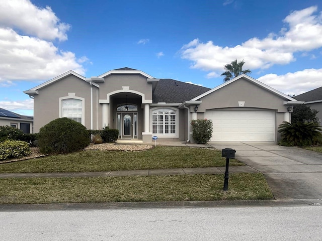 single story home featuring an attached garage, a front lawn, stucco siding, and concrete driveway