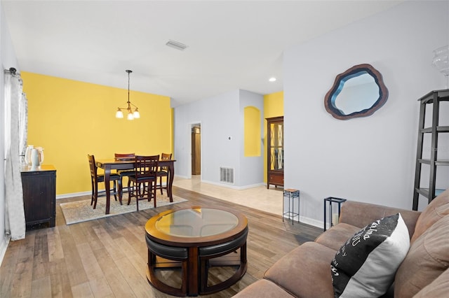 living room featuring baseboards, visible vents, and wood finished floors