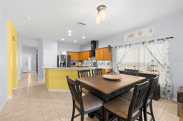 dining room with visible vents, arched walkways, light tile patterned floors, baseboards, and recessed lighting