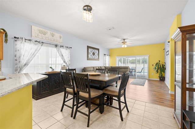 dining area featuring baseboards, ceiling fan, visible vents, and light tile patterned floors