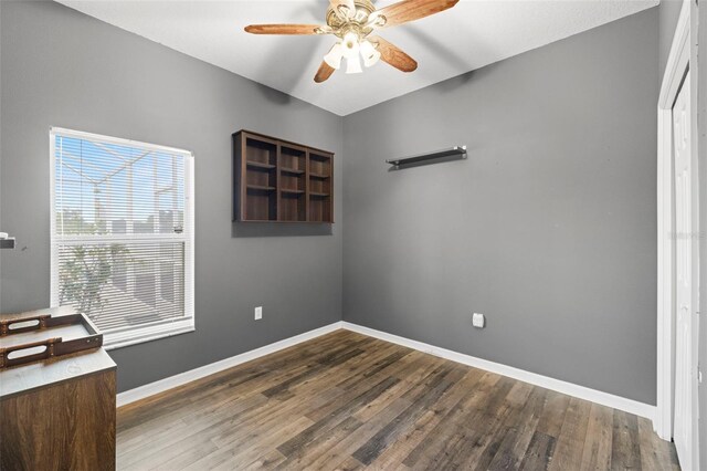 spare room with baseboards, ceiling fan, and wood finished floors