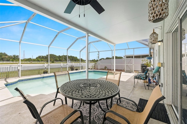 view of swimming pool with a ceiling fan, a patio area, glass enclosure, a fenced in pool, and a fenced backyard