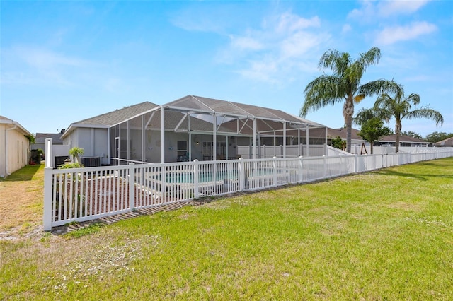 rear view of property with a fenced backyard, a patio area, a swimming pool, a lanai, and a yard