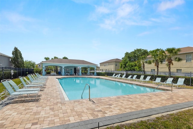 community pool with a patio area and fence