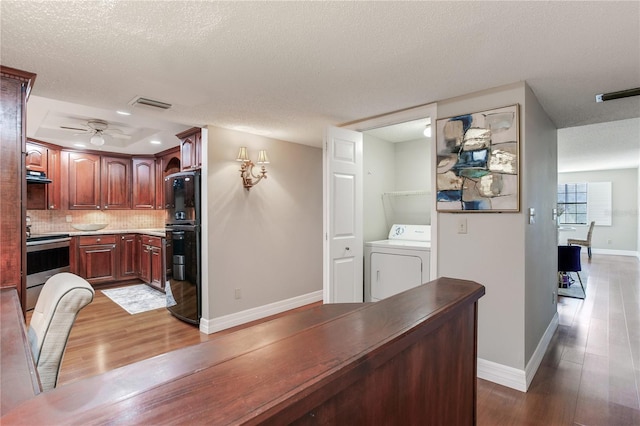 14820 Rue De Bayonne Unit 208, Clearwater, FL 33762 - kitchen featuring washer / dryer, freestanding refrigerator, wood finished floors, and stainless steel range with electric stovetop