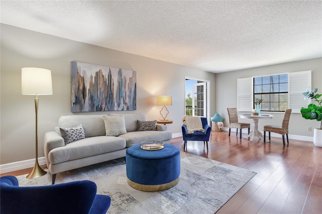14820 Rue De Bayonne Unit 208, Clearwater, FL 33762 - living area featuring baseboards, a textured ceiling, and wood finished floors